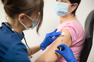 Image showing Close up doctor or nurse giving vaccine to patient using the syringe injected in hospital