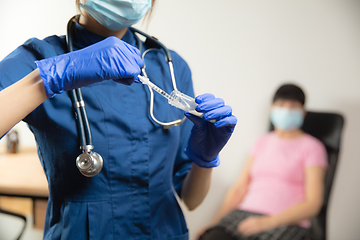 Image showing Doctor or nurse giving vaccine to patient using the syringe injected in hospital