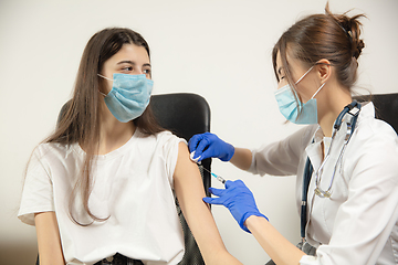 Image showing Close up doctor or nurse giving vaccine to patient using the syringe injected in hospital