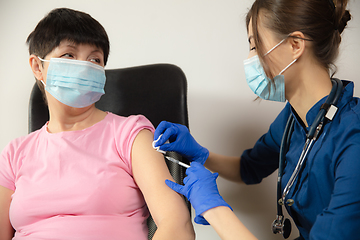 Image showing Close up doctor or nurse giving vaccine to patient using the syringe injected in hospital