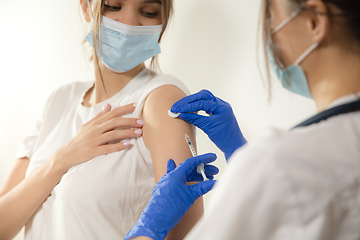 Image showing Close up doctor or nurse giving vaccine to patient using the syringe injected in hospital