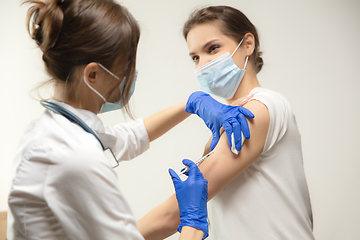 Image showing Close up doctor or nurse giving vaccine to patient using the syringe injected in hospital