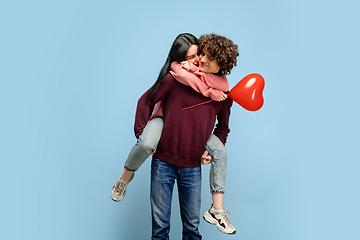 Image showing Beautiful couple in love on blue studio background. Valentine\'s Day, love and emotions concept