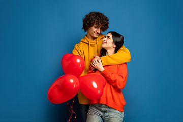 Image showing Beautiful couple in love on blue studio background. Valentine\'s Day, love and emotions concept