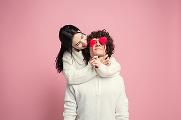 Image showing Young, beautiful couple in love on pink studio background. Valentine\'s Day, love and emotions concept