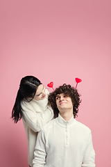 Image showing Young, beautiful couple in love on pink studio background. Valentine\'s Day, love and emotions concept