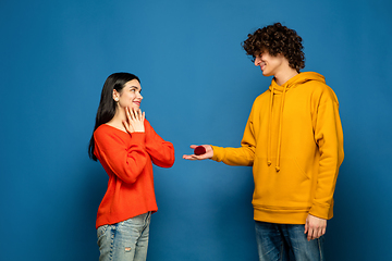 Image showing Beautiful couple in love on blue studio background. Valentine\'s Day, love and emotions concept