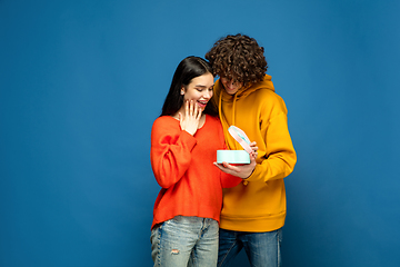 Image showing Beautiful couple in love on blue studio background. Valentine\'s Day, love and emotions concept