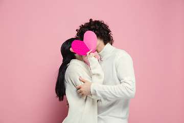 Image showing Young, beautiful couple in love on pink studio background. Valentine\'s Day, love and emotions concept