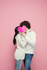 Image showing Young, beautiful couple in love on pink studio background. Valentine\'s Day, love and emotions concept