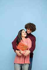 Image showing Beautiful couple in love on blue studio background. Valentine\'s Day, love and emotions concept