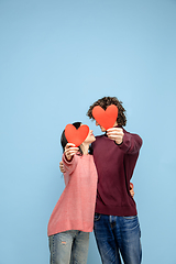 Image showing Beautiful couple in love on blue studio background. Valentine\'s Day, love and emotions concept