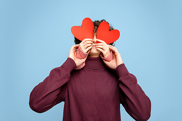 Image showing Beautiful couple in love on blue studio background. Valentine\'s Day, love and emotions concept