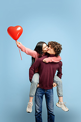 Image showing Beautiful couple in love on blue studio background. Valentine\'s Day, love and emotions concept