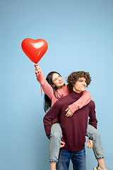 Image showing Beautiful couple in love on blue studio background. Valentine\'s Day, love and emotions concept