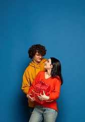 Image showing Beautiful couple in love on blue studio background. Valentine\'s Day, love and emotions concept