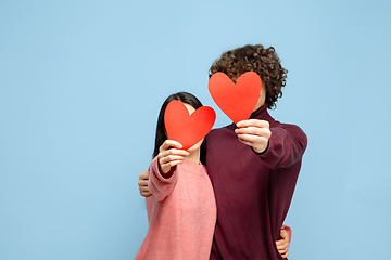 Image showing Beautiful couple in love on blue studio background. Valentine\'s Day, love and emotions concept
