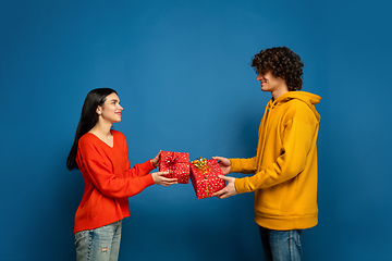 Image showing Beautiful couple in love on blue studio background. Valentine\'s Day, love and emotions concept