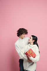 Image showing Young, beautiful couple in love on pink studio background. Valentine\'s Day, love and emotions concept