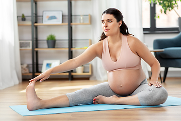 Image showing happy pregnant woman doing sports at home