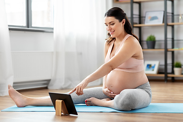 Image showing pregnant woman with tablet pc doing sports at home