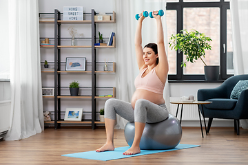 Image showing pregnant woman with dumbbells doing sports at home