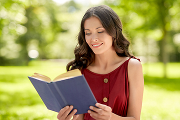 Image showing happy smiling woman reading book at park