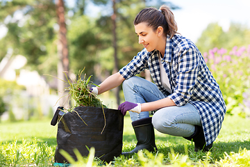 Image showing woman weeding flowerbed at summer garden