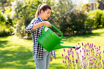 Image showing young woman watering flowers at garden