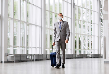 Image showing businessman in mask with travel bag at airport