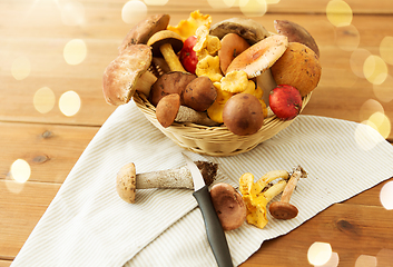 Image showing basket of different edible mushrooms and knife