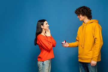 Image showing Beautiful couple in love on blue studio background. Valentine\'s Day, love and emotions concept