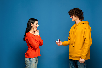 Image showing Beautiful couple in love on blue studio background. Valentine\'s Day, love and emotions concept