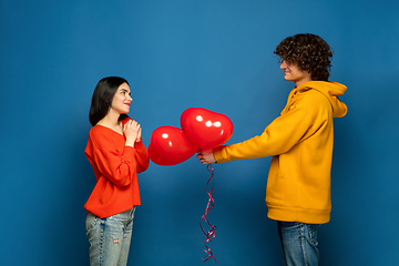 Image showing Beautiful couple in love on blue studio background. Valentine\'s Day, love and emotions concept