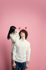 Image showing Young, beautiful couple in love on pink studio background. Valentine\'s Day, love and emotions concept