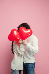 Image showing Young, beautiful couple in love on pink studio background. Valentine\'s Day, love and emotions concept