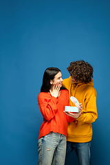 Image showing Beautiful couple in love on blue studio background. Valentine\'s Day, love and emotions concept