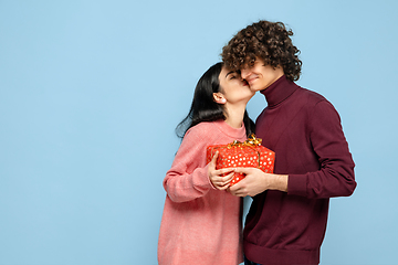 Image showing Beautiful couple in love on blue studio background. Valentine\'s Day, love and emotions concept