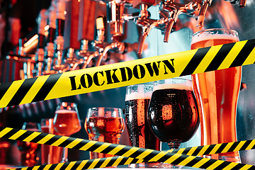 Image showing Glasses of different types of beer at bar with bounding tapes Lockdown, Coronavirus, Quarantine, Warning - closing bars and nightclubs during pandemic