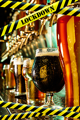 Image showing Glasses of different types of beer at bar with bounding tapes Lockdown, Coronavirus, Quarantine, Warning - closing bars and nightclubs during pandemic