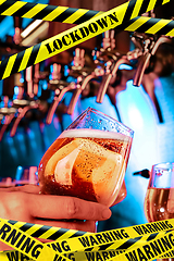 Image showing Hand of bartender pouring a beer in tap with bounding tapes Lockdown, Coronavirus, Quarantine, Warning - closing bars and nightclubs during pandemic