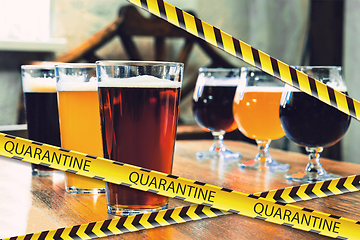 Image showing Glasses of different types of beer at bar with bounding tapes Lockdown, Coronavirus, Quarantine, Warning - closing bars and nightclubs during pandemic