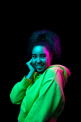 Image showing African-american woman\'s portrait isolated on dark studio background in multicolored neon light