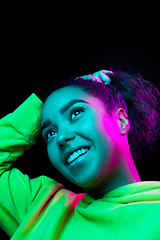 Image showing African-american woman\'s portrait isolated on dark studio background in multicolored neon light