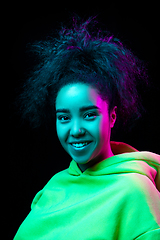 Image showing African-american woman\'s portrait isolated on dark studio background in multicolored neon light