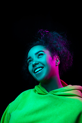 Image showing African-american woman\'s portrait isolated on dark studio background in multicolored neon light