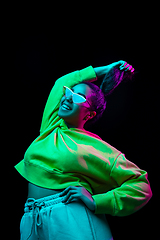 Image showing African-american woman\'s portrait isolated on dark studio background in multicolored neon light