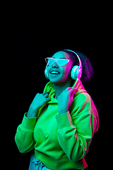 Image showing African-american woman\'s portrait isolated on dark studio background in multicolored neon light