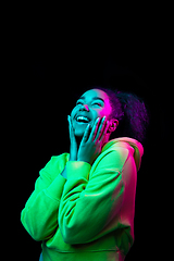 Image showing African-american woman\'s portrait isolated on dark studio background in multicolored neon light