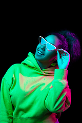 Image showing African-american woman\'s portrait isolated on dark studio background in multicolored neon light